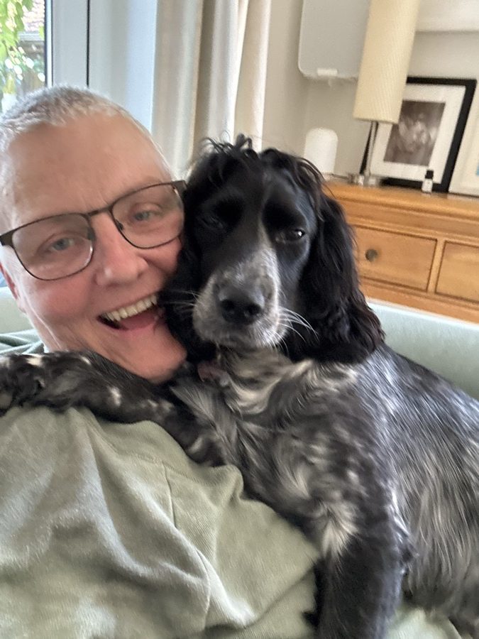 Michelle on the sofa with Dessi, a black and white spaniel